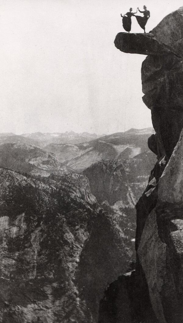 Due donne fanno acrobazie in cima alla Roccia Sporgente a Glacier Point nel Parco Nazionale di Yosemite, 1900