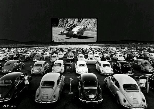 Volkswagen Beetle guardano 'Herbie - The Love Bug' in un teatro drive-in, c. 1960