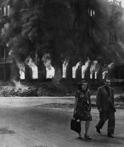 Una coppia cammina per le strade di Berlino in fiamme negli ultimi giorni della guerra, 1945