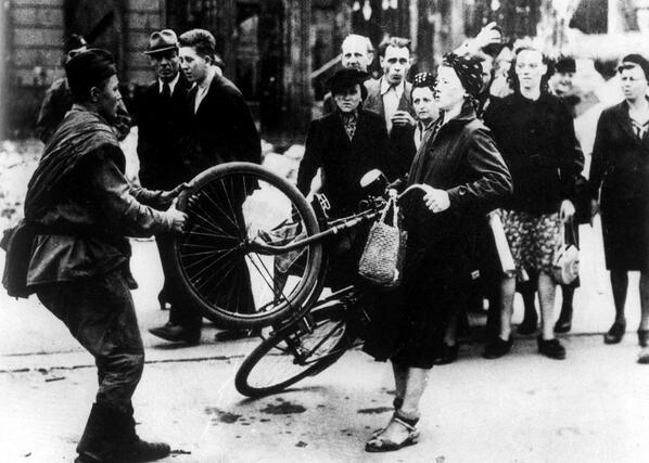 Un soldato russo cerca di rubare la bicicletta a una donna, ma lei si rifiuta. Berlino, 1945