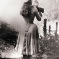 Annie Oakley spara sopra la sua spalla con uno specchio in mano