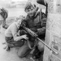 Un soldato britannico lascia che giovane ragazzo guardi attraverso il mirino del suo fucile a Belfast, 1981