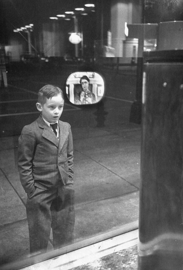 Ragazzo guarda per la prima volta una TV in una finestra negozio di elettrodomestici, 1948