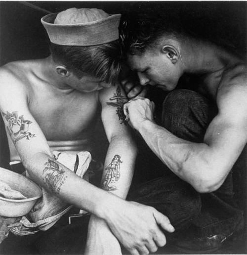 Un marinaio americano tatuato da un compagno di bordo sulla USS New Jersey nel loro cammino verso il Pacifico, dicembre 1944