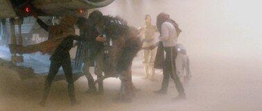 A wounded Chewie being led into the Falcon