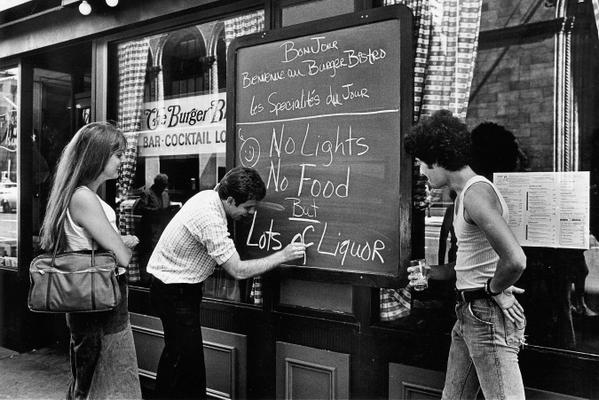Il proprietario di un ristorante mette un cartello durante il blackout di New York del 13 Luglio 1977