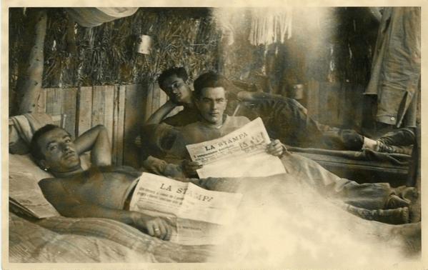 Italiani in Somalia in branda con quotidiano. 1936