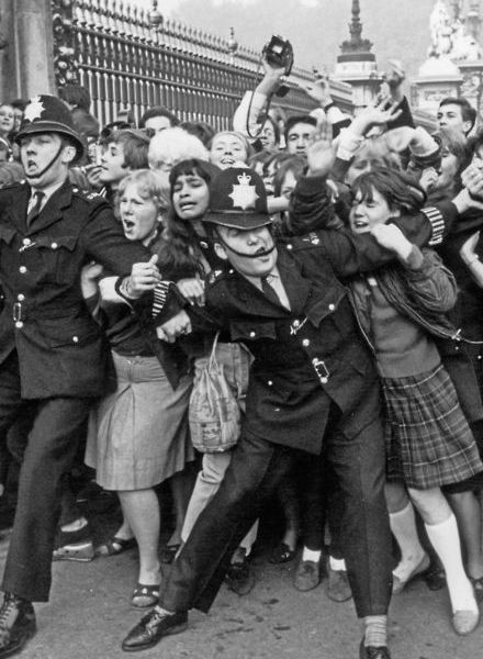 La polizia che lotta per frenare i fan dei Beatles fuori da Buckingham Palace nell'ottobre del 1965