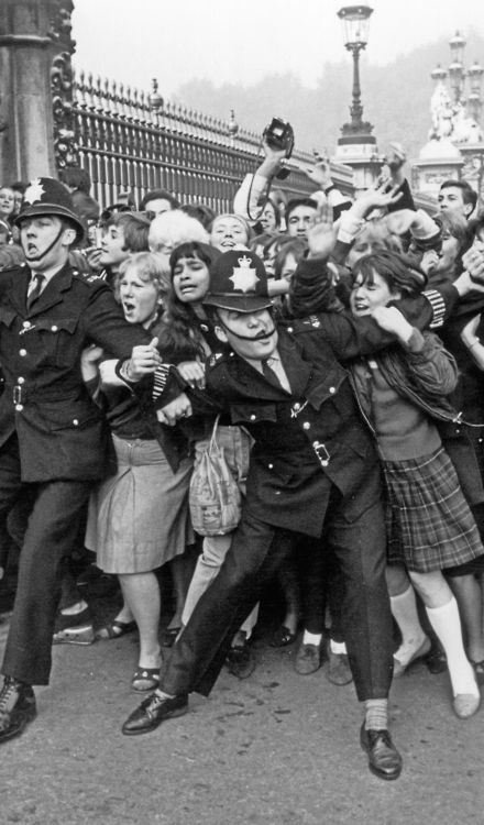 La polizia che lotta per frenare i fan dei Beatles fuori da Buckingham Palace nell'ottobre del 1965