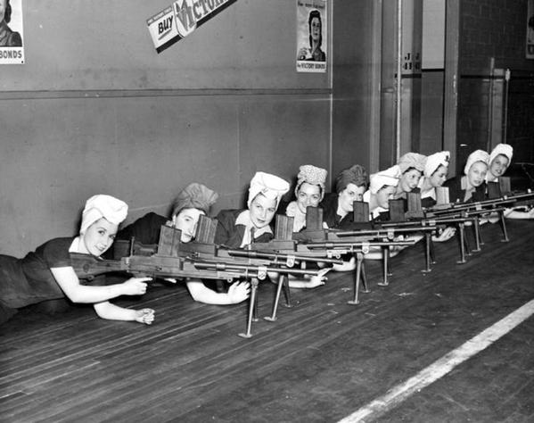 Donne che lavorano nelle fabbriche testano le pistole che hanno prodotto per la seconda guerra mondiale