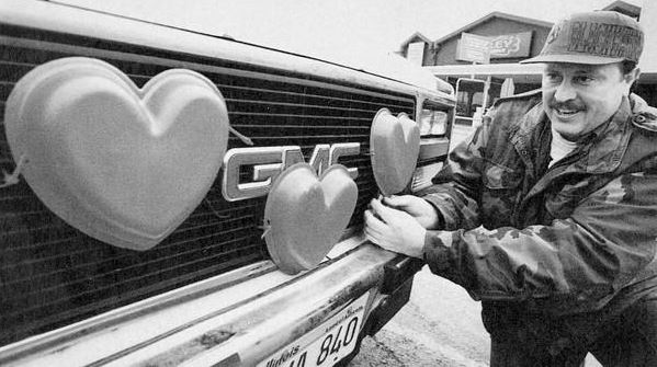 Un tizio adorna la macchina con cuori rossi per San Valentino