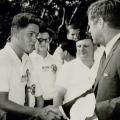Un adolescente Bill Clinton che stringe la mano a John Kennedy