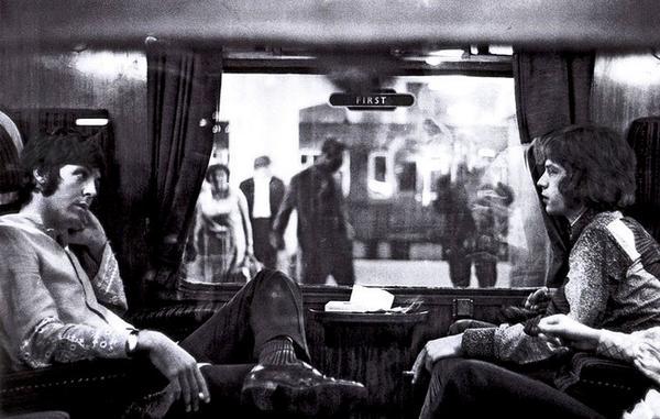 Paul McCartney e Mick Jagger che siedono uno di fronte all'altro su un treno a Bangor. (1967)
