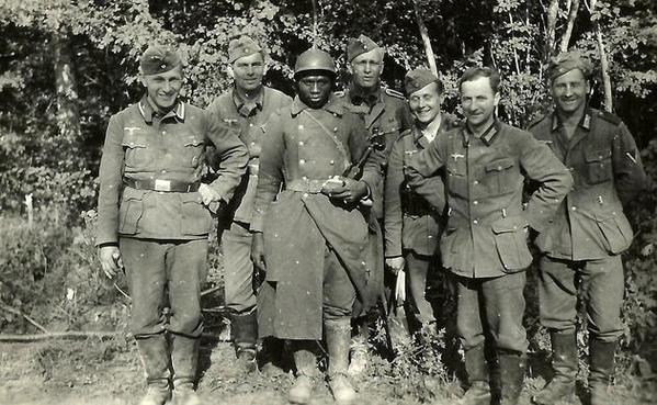 Tedeschi in posa con un prigioniero di guerra francese. Francia, 1940