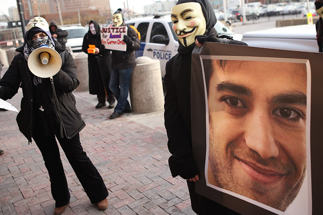 I membri del gruppo Anonymous protestano mostrando una foto di Aaron Swartz