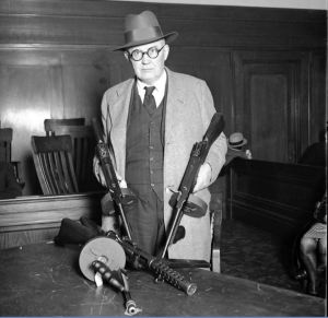 Il capitano William 'Shoes' Schoemaker mostra le mitragliatrici durante l'inchiesta per la Strage di San Valentino, il 19 aprile, 1929. Il coroner Bundesen convocò tutti i concessionari di armi della zona che trattavano mitragliatrici alla giuria del coroner a Chicago. - Chicago Tribune historical photo