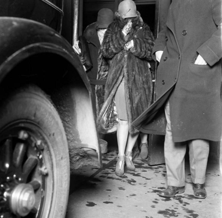 La signora Myrtle Gorman, al centroe, di 434 Roscoe Street, era la moglie di Peter Gusenberg, un capobanda di George "Bugs" Moran. Gusenberg, 40 anni, è stato assassinato durante la Strage di San Valentino. La signora Gorman ha negato la conoscenza dell'attività del marito e lascia il palazzo di giustizia dopo l'inchiesta del coroner. - Chicago Tribune historical photo