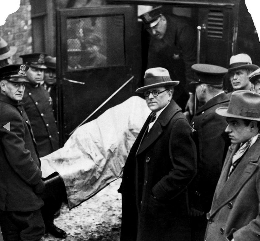 Il corpo di una delle sette vittime è posto in un'ambulanza col medico legale Herman N. Bundesen, al centro. - Chicago Tribune historical photo