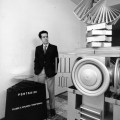 Ugo Ugo alla Galleria Comunale nei primi anni 70 con l’opera Portagiri (1970) di Vincenzo Agnetti e, alla sua destra, una sua scultura di fine anni 60