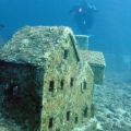 A 30 metri sotto il livello del mare, al largo del Cap d’Antibes, si trovano i resti di una cittadina francese sommersa sottomarina completa di case e edifici alti fino a 1 m. La città acquatica fu costruita nel 1965 da registi francesi che volevano girare parti del loro film, L’Enfant et la Sirène, su un vero set di film sott’acqua. L’ambizioso approccio di ripresa subacquea è stato abbandonato per l’animazione. Sfortunatamente, il film – un musical diretto da Sylver Néjad Atzamba – non è mai uscito e il set è stato lasciato sul fondo del mare.