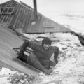 Xavier Mertz che esce dalla cabina attraverso la botola sul tetto della terrazza. Fotografia di Frank Hurley