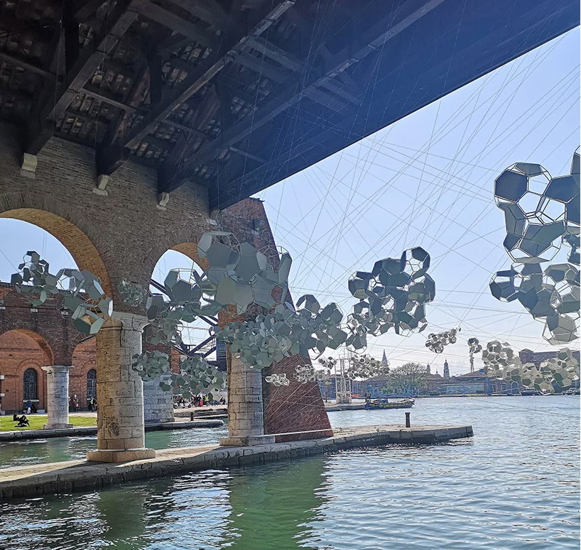 Aero(s)cene by Tomás Saraceno @ Biennale Arte 2019 - The sun draws sound waves in light on the water, reflecting a score in elemental motion image © designboom