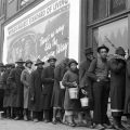 UNITED STATES – FEBRUARY 02: African American flood victims lined up to get food & clothing fr. Red Cross relief station in front of billboard ironically extolling WORLD’S HIGHEST STANDARD OF LIVING/ THERE’S NO WAY LIKE THE AMERICAN WAY. (Photo by Margaret Bourke-White/The LIFE Picture Collection via Getty Images)