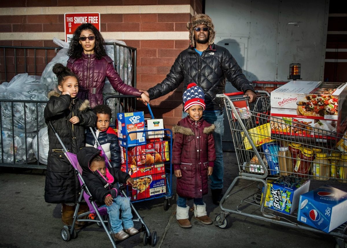 Karena Salcedo, venticinque anni, guardia di sicurezza, e Dave Johnson, trenta, camionista, con Serenity, sette, Seriyah, cinque, Evan, tre e Kaylani, uno e mezzo. BJ's Wholesale, East New York. Fotografia di Dina Litovsky