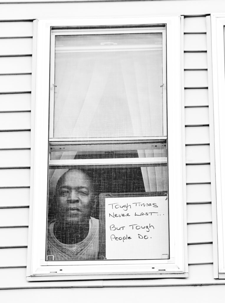 Robert E. Clark Jr. poses for 'Words At The Window: Self Isolation And The Coronavirus', a portrait series by Shutterstock Staff Photographer, Stephen Lovekin, shot around the Ditmas Park neighborhood of Brooklyn, New York.