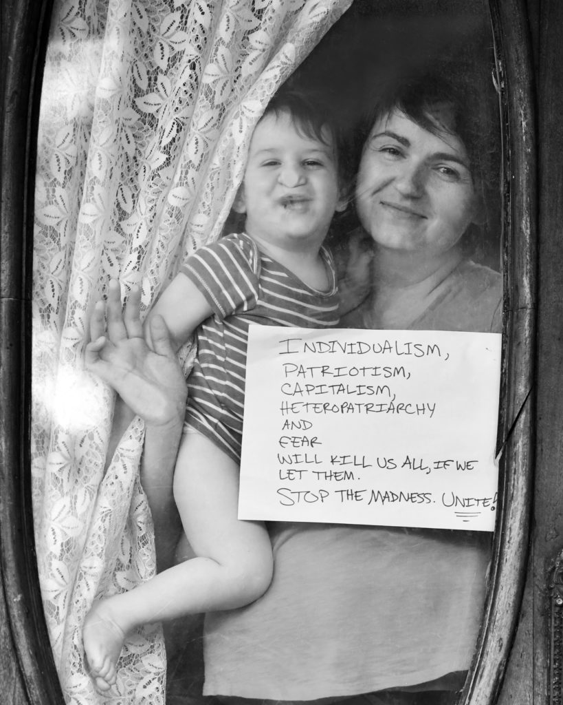 Khadijah Silver and son Eliot pose for 'Words At The Window: Self Isolation And The Coronavirus', a portrait series by Shutterstock Staff Photographer, Stephen Lovekin, shot around the Ditmas Park neighborhood of Brooklyn, New York.