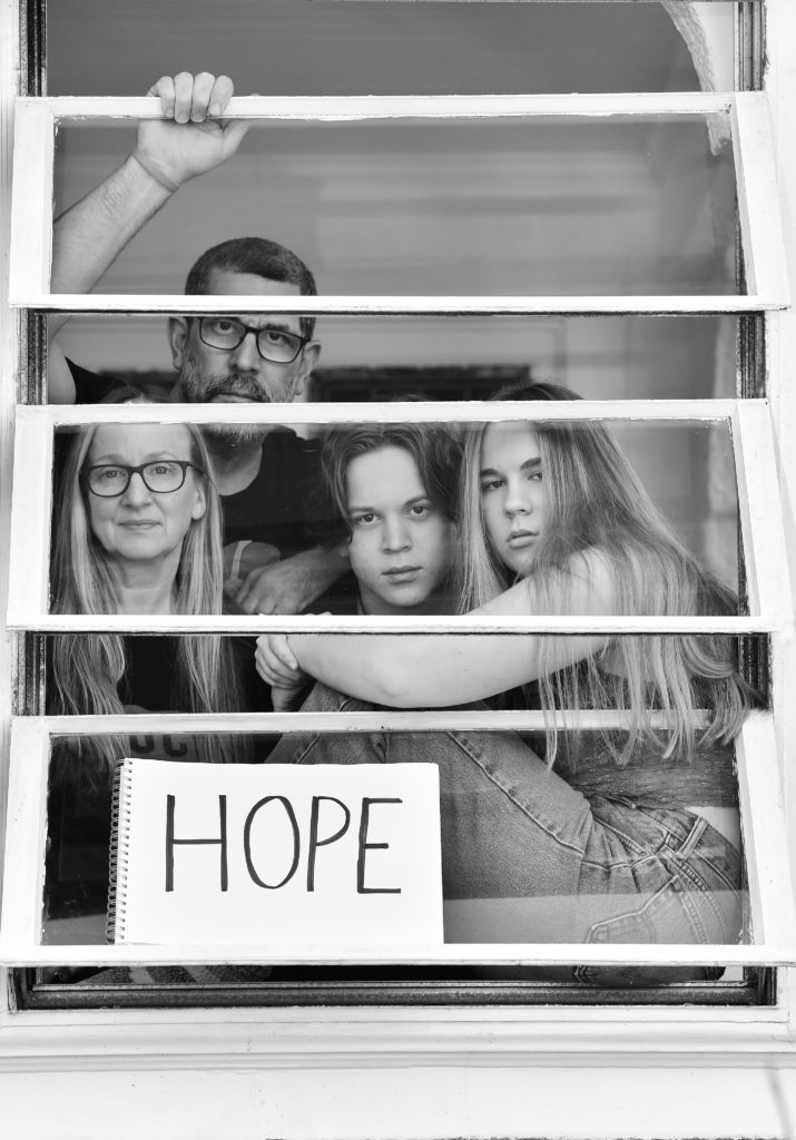 Agnetha Septimus, Matthew Septimus, and children Ezra and Nora, pose for 'Words At The Window: Self Isolation And The Coronavirus', a portrait series by Shutterstock Staff Photographer, Stephen Lovekin, shot around the Ditmas Park neighborhood of Brooklyn, New York.