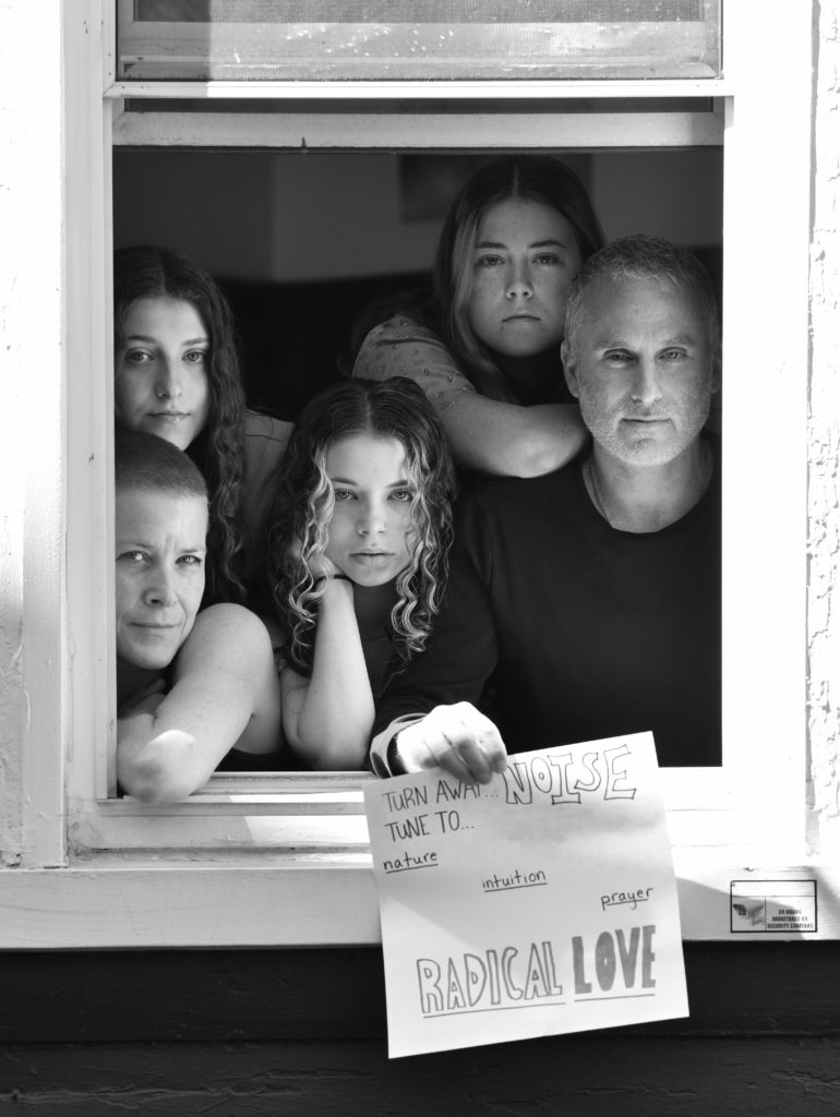 Jean Davis and Danny Rosenthal, with children Simone, Naomi, and Leah, pose for 'Words At The Window: Self Isolation And The Coronavirus', a portrait series by Shutterstock Staff Photographer, Stephen Lovekin, shot around the Ditmas Park neighborhood of Brooklyn, New York.
