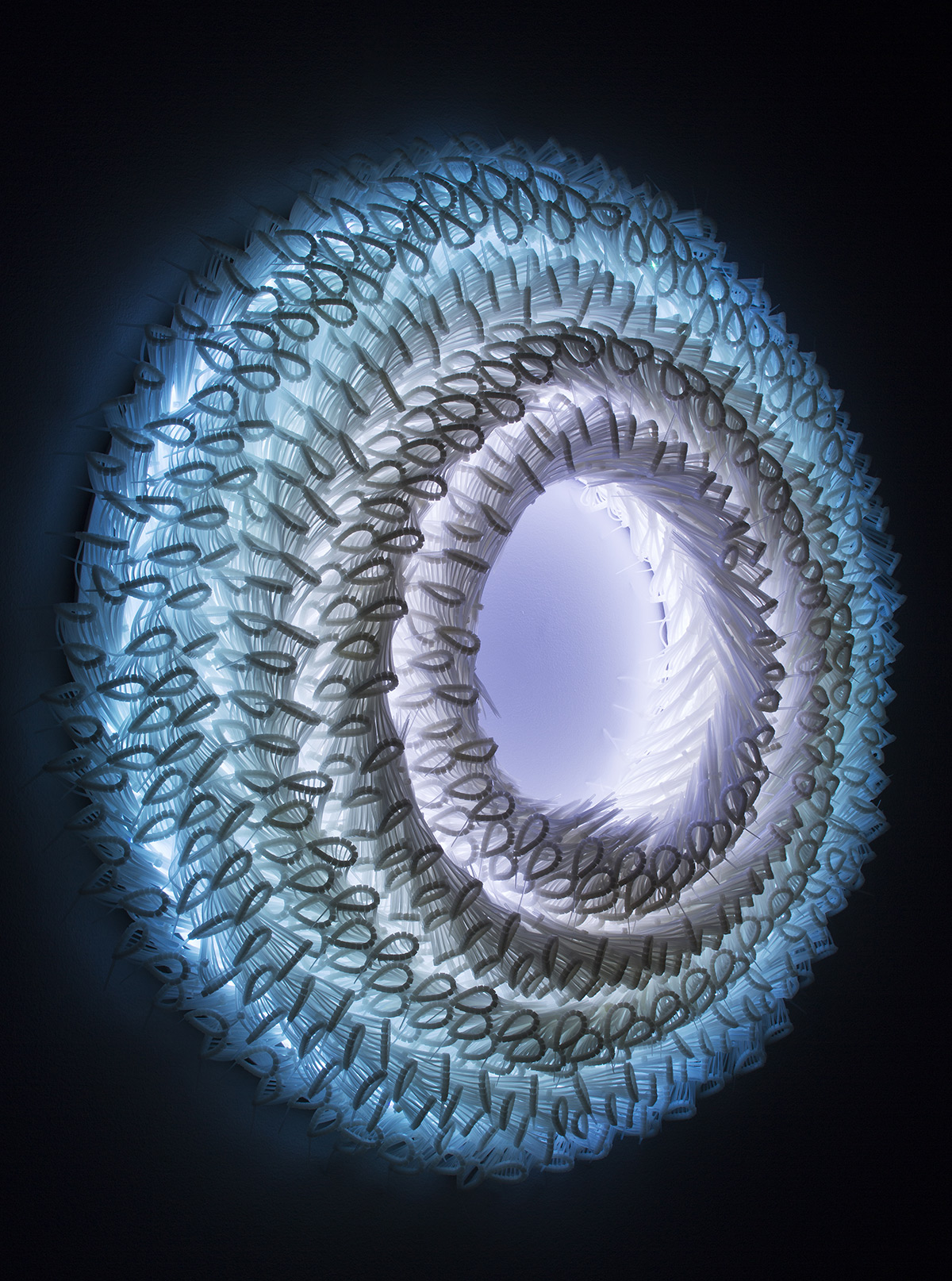 Elisabeth Picard. “Ondulation” (2014), white zip-ties, RGB LED light, and painted plywood,  36 x 36 x 6 ¼ inches.  Photo by Michel Dubreuil