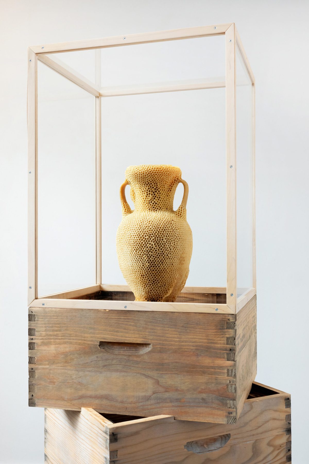 “The Honeycomb Amphora” (2020), natural beeswax, museum glass, wood, re-used beehives , 47 x 42 x 147 centimeters. All images © Tomáš Libertíny