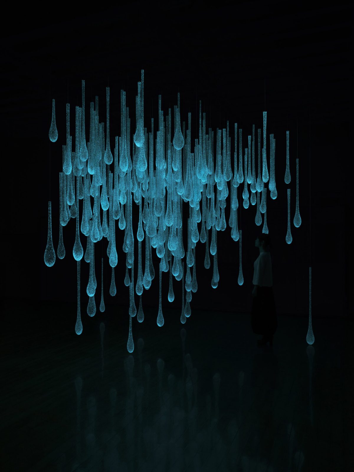 Rui Sasaki. “Liquid Sunshine/I am a Pluviophile” (2019), glass, phosphorescent material, broad-spectrum UV lights, motion detector, 3,353 x 4,267 x 3,658 millimeters as installation. Photo by Yasushi Ichikawa, 33rd Rakow Commission, courtesy of The Corning Museum of Glass