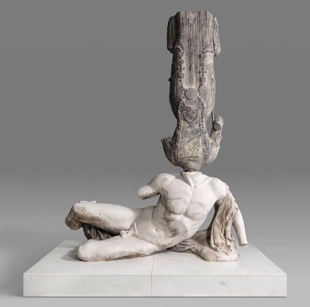 Xu Zhen - From Eternity series - Northern Qi painted Bodhisattva, River God Ilissos from West Pediment of Parthenon, 2018. Mineral based composite, mineral pigments, stainless steel, marble. Xu Zhen's 'Eternity' is a series of sculptural installations composed of replicas made from compound minerals. To create the amalgamations, the artist selects from classic statues of Western and Asian civilizations, like that of Buddha statues sourced from temples across China. The artist has taken a provocative but also humorous approach to highlight the differences in Western and Eastern cultures. The sculptures of the Greek Gods mark the beginning of Western civilization while the statues of Buddha represent enlightenment in it's highest form. The migration of these timeless art pieces recount the history of colonization, international politics and war. By combining the two aesthetically and culturally opposing elements, Zhen brings cultural conflict and the power struggle of human history to the foreground.