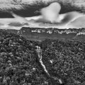 Il territorio indigeno Raposa-Serra do Sol occupa due aree ecologicamente distinte: i campi a sud e le montagne densamente boscose a nord. Il suo punto di riferimento principale è il Monte Roraima, visto sullo sfondo, il cui nome è associato all’eroe mitologico Makunaima. Questo eroe ha ispirato il romanzo classico Macunaíma dell’autore brasiliano Mario de Andrade. Ci sono circa 140 villaggi Macuxi. Cascate del fiume Cotingo. Stato di Roraima, 2018. Fotografia di Sebastião Salgado