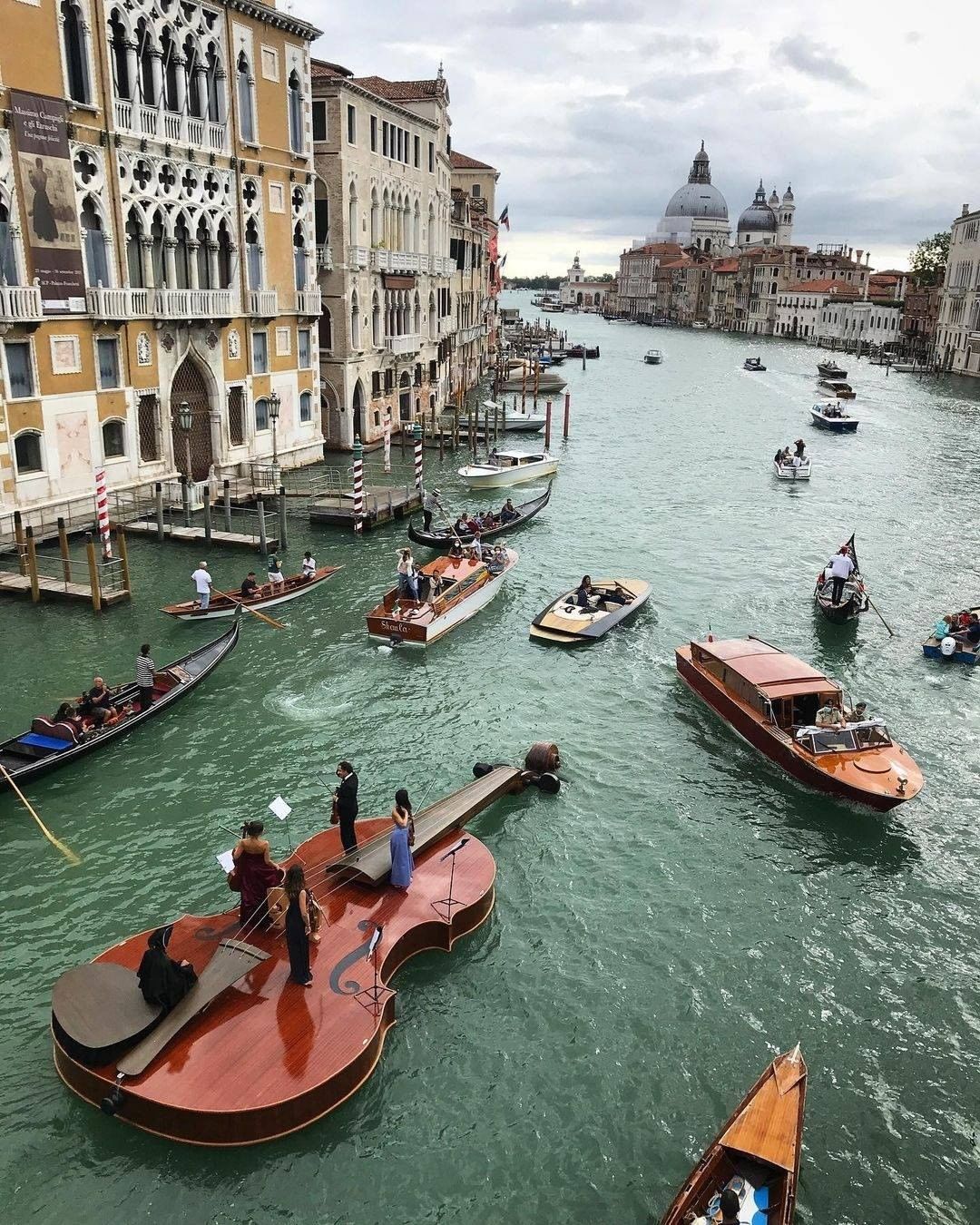 This giant violin floating on the canals of Venice, captured by Luca De Luigi. Boat created by Livio De Marchi