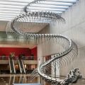 “Ressort” è una scultura lunga 170 piedi di uno scheletro di serpente dell’artista cinese Huang Yong Ping. Costruita in alluminio e acciaio inossidabile, l’imponente scultura è sospesa sopra una piscina interna riflettente presso la Queensland Art Gallery a Brisbane, Australia